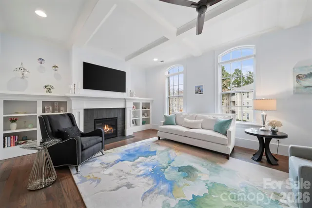 a living room with furniture a fireplace and a flat screen tv