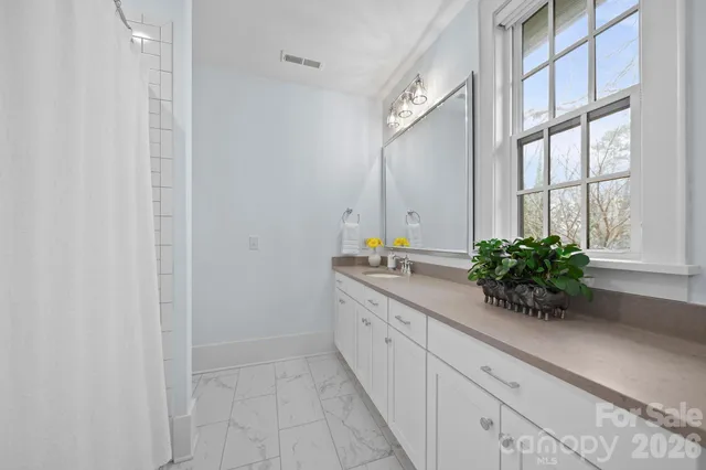 a bathroom with a granite countertop sink a vanity and a tub