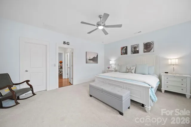 a spacious bedroom with a bed and a chandelier