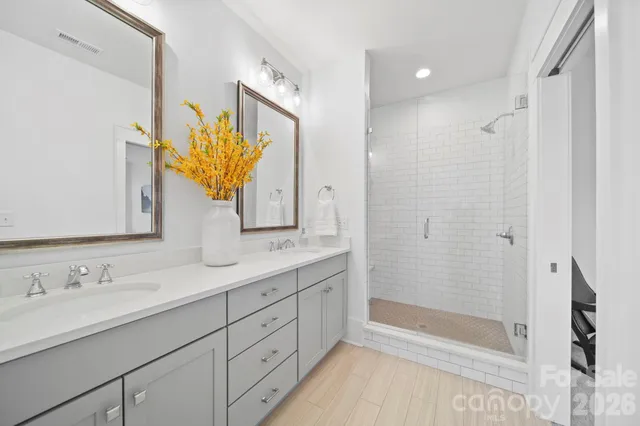 a bathroom with a double vanity sink mirror and shower