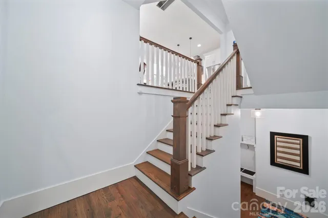 a view of staircase with wooden floor and white walls