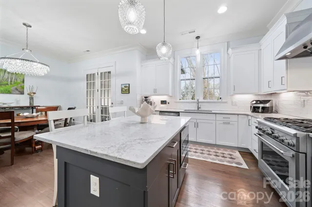 a kitchen with a stove a sink dishwasher a kitchen island with wooden cabinets and floor