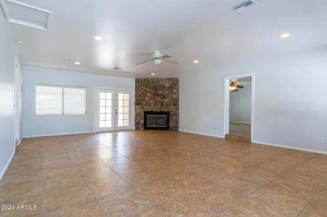 an empty room with windows and fireplace