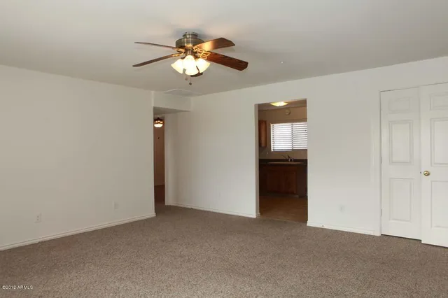 a view of an empty room with a chandelier fan