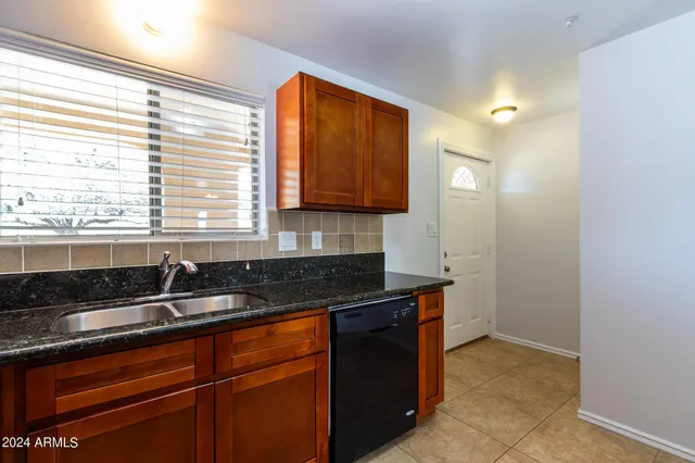 a kitchen with granite countertop cabinets sink and window