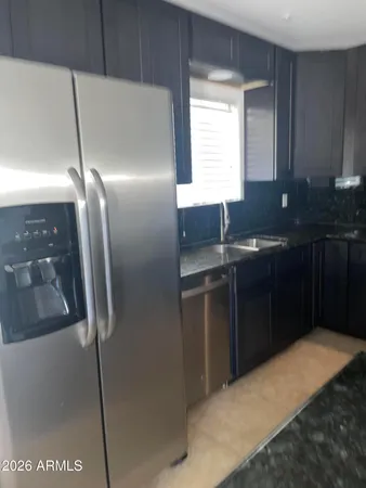 a kitchen with kitchen island granite countertop a sink cabinets and stainless steel appliances