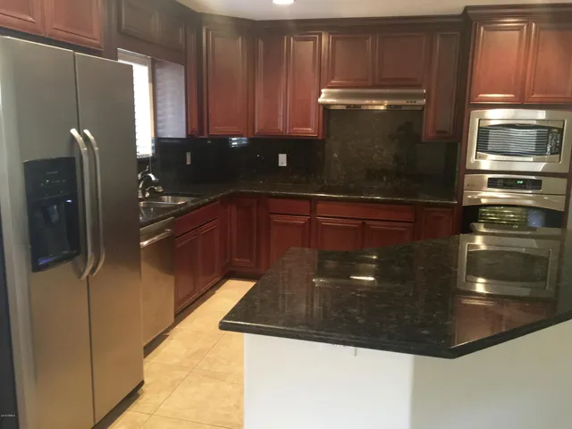 a kitchen with granite countertop stainless steel appliances and wooden cabinets