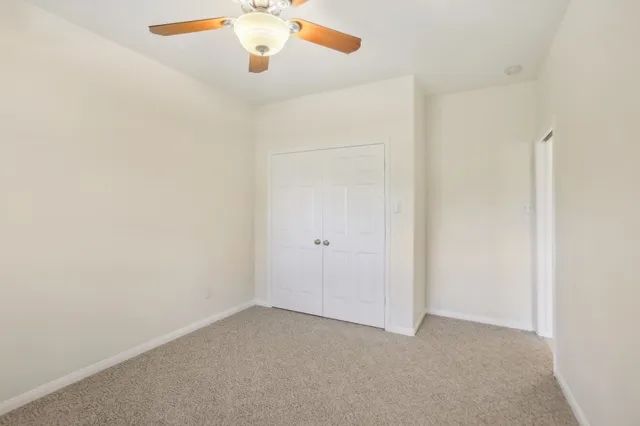 an empty room with a window and a fan