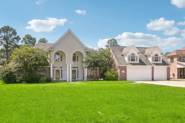 a view of a big house with a big yard and potted plants