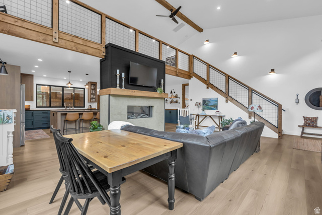 1766 West Tollgate Cyn Road Coalville, UT 84017 - Photo 6 of 59 Open-concept living area with vaulted ceilings, light wood-finish flooring, and a modern fireplace