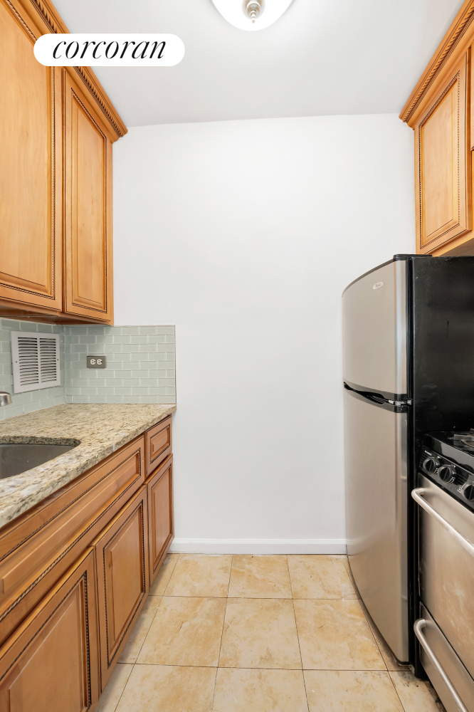 330 East 70th Street, Unit 5G Manhattan, NY 10021 - Photo 7 of 17 a kitchen with stainless steel appliances granite countertop a sink and a refrigerator