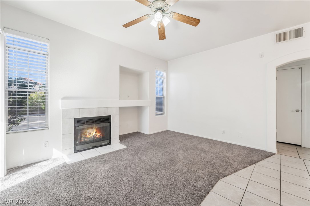 2201 Ramsgate Drive, Unit 811 Henderson, NV 89074 - Photo 3 of 36 Warm up by the tile-surrounded fireplace in this naturally illuminated living space with a ceiling fan.