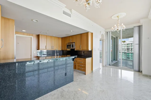 a large kitchen with kitchen island a large counter top space a sink stainless steel appliances and cabinets
