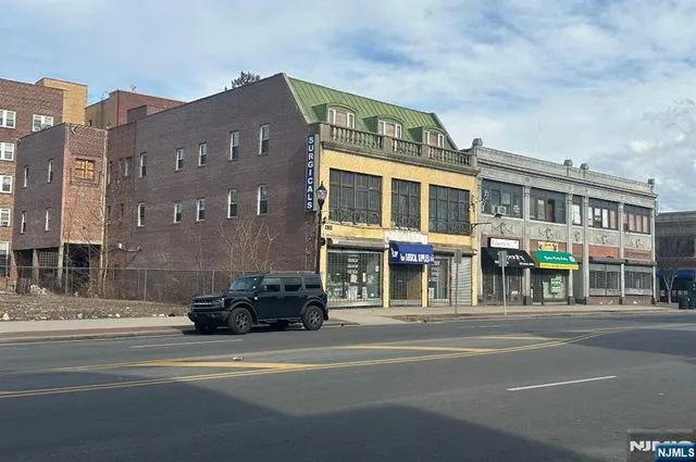 a front view of a building and car parked
