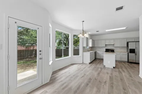 a open kitchen with white cabinets and wooden floor
