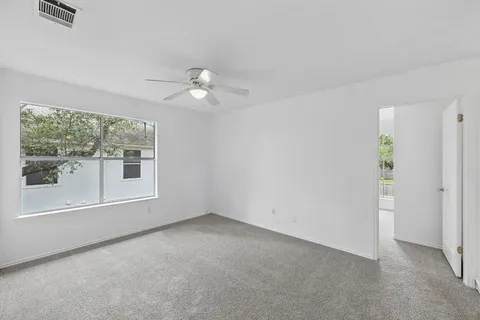 a view of an empty room with a ceiling fan