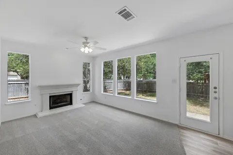 a view of an empty room with window and fire place