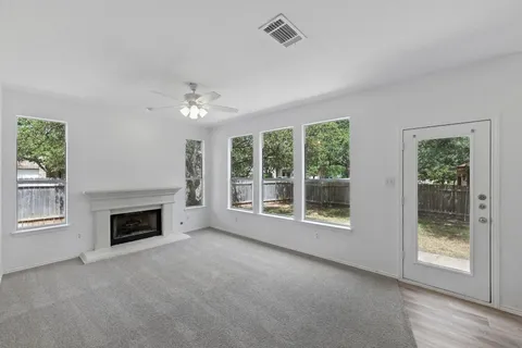 a view of an empty room with window and fire place