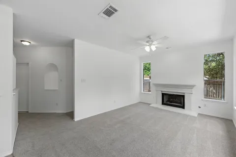 an empty room with windows and fireplace