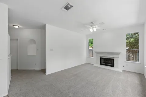 an empty room with windows and fireplace
