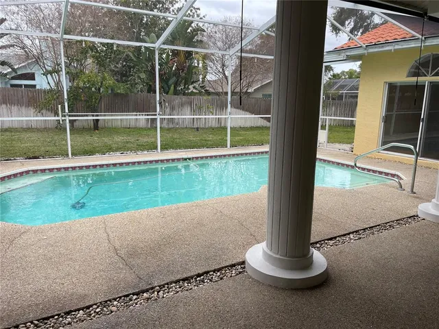 an empty room with wooden floor and windows with curtains