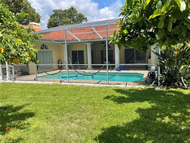 a view of house with backyard and swimming pool