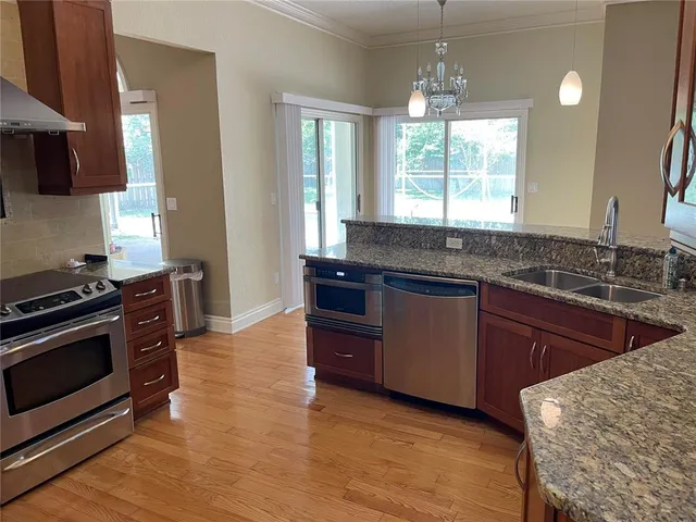 a kitchen with granite countertop a stove and a sink