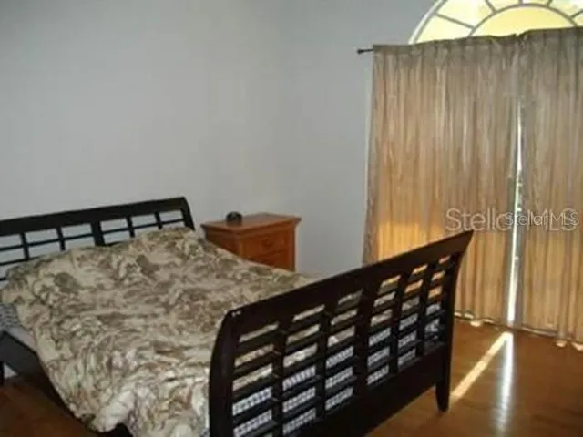 a bed sitting in a bedroom next to a window