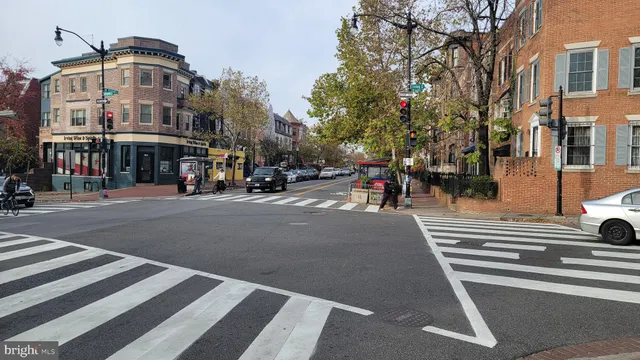 a front view of a building with street view and trees