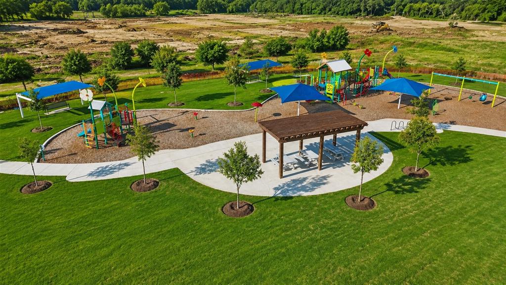 16936 Post Cedar Drive Justin, TX 76247 - Photo 26 of 30 Community park featuring a large play structure, multiple swing sets, a shaded pergola with picnic tables, and abundant green space