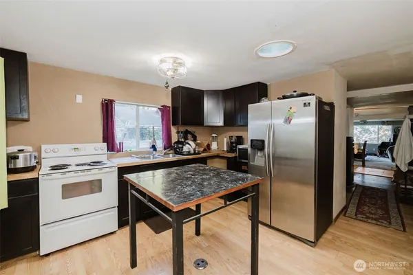a kitchen with a stove a refrigerator and a sink