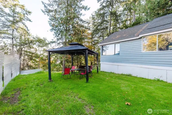 a view of a backyard with a table and chairs under an umbrella