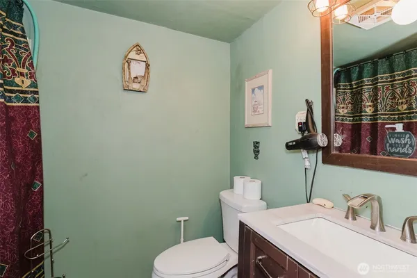 a bathroom with a toilet sink and mirror