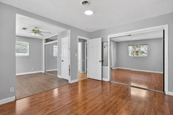 an empty room with wooden floor and window