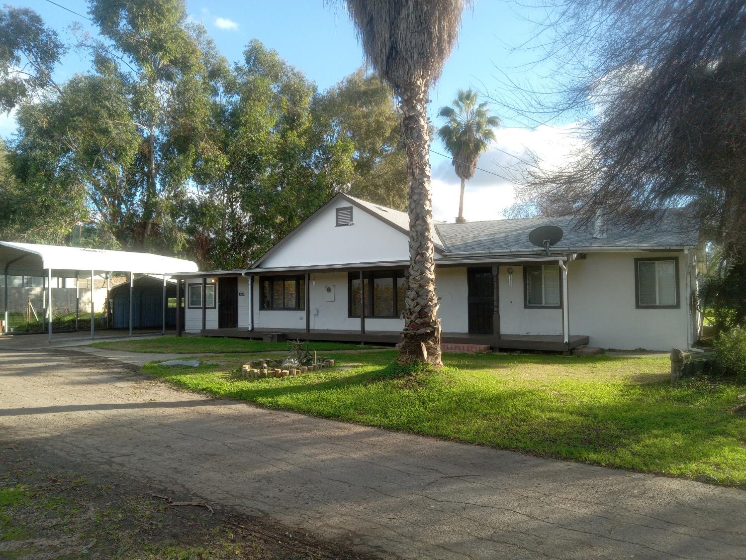 602 South Spruce Road Exeter, CA 93221 - Photo 2 of 28 a front view of a house with a garden and trees