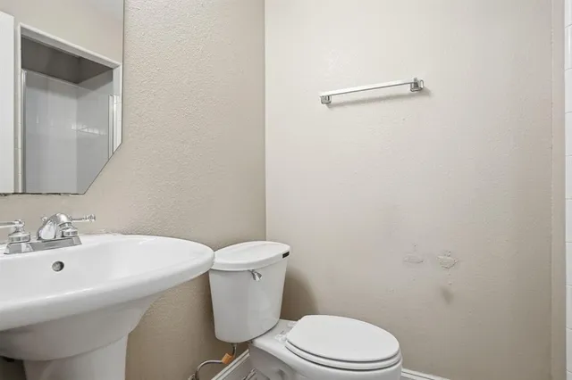 a white toilet sitting next to a bathroom sink