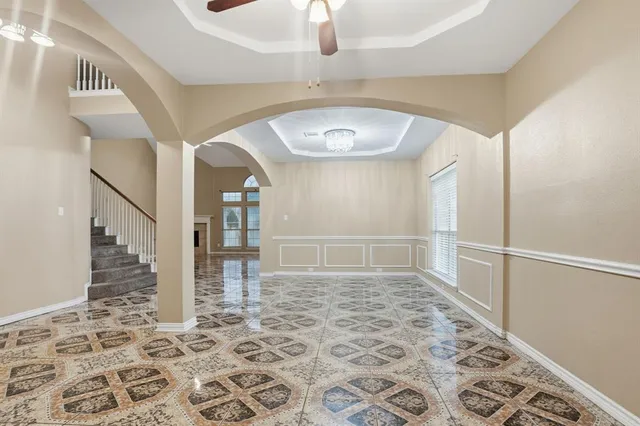 a view of a hallway with wooden floor and a chandelier