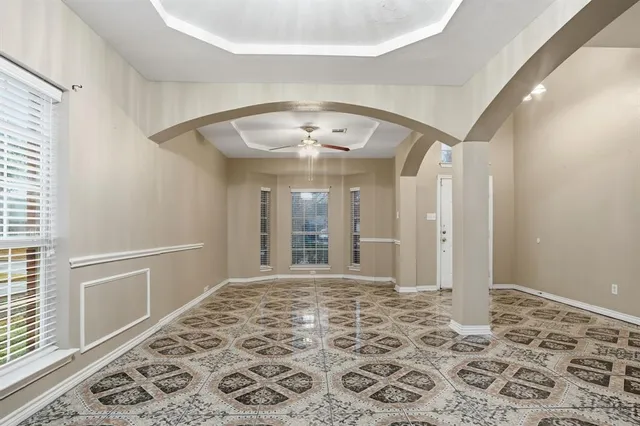 a view of a big room with a chandelier and wooden floor