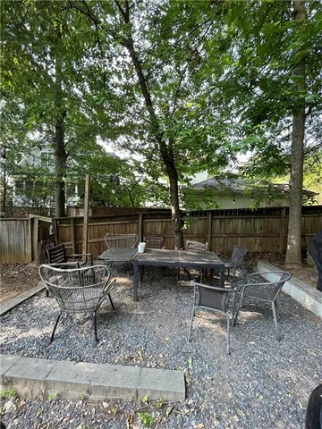 a backyard of a house with fountain table and chairs