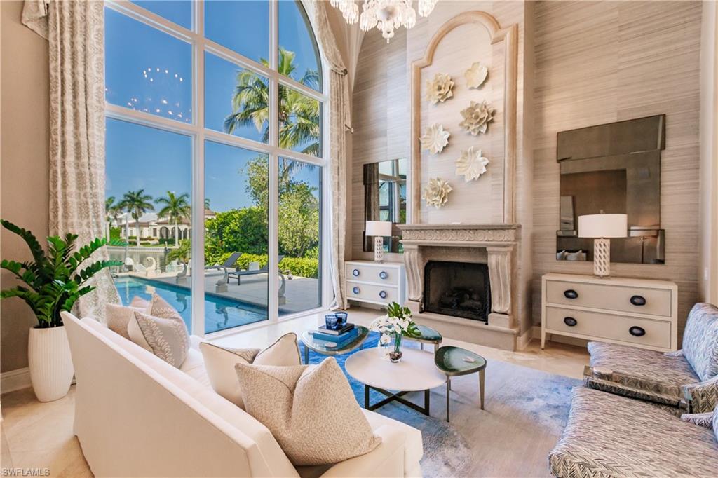 2450 Tarpon Road Naples, FL 34102 - Photo 12 of 26 a living room with furniture a fireplace and windows