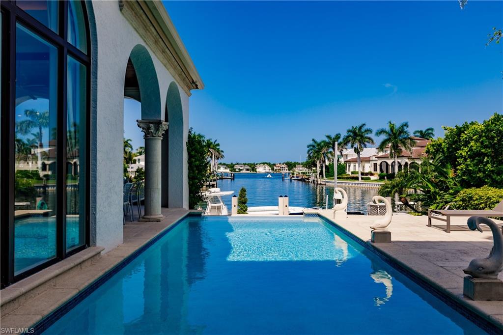 2450 Tarpon Road Naples, FL 34102 - Photo 7 of 26 a view of a swimming pool with outdoor seating