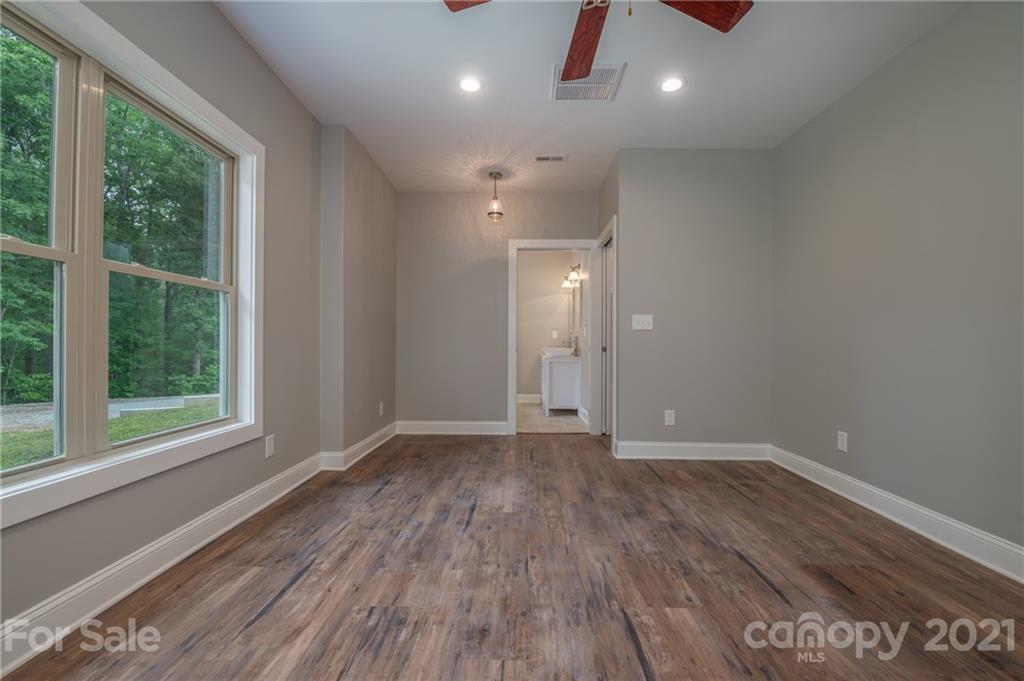 196 Caledonia Road Landrum, SC 29356 - Photo 14 of 26 a view of an empty room with wooden floor and a window