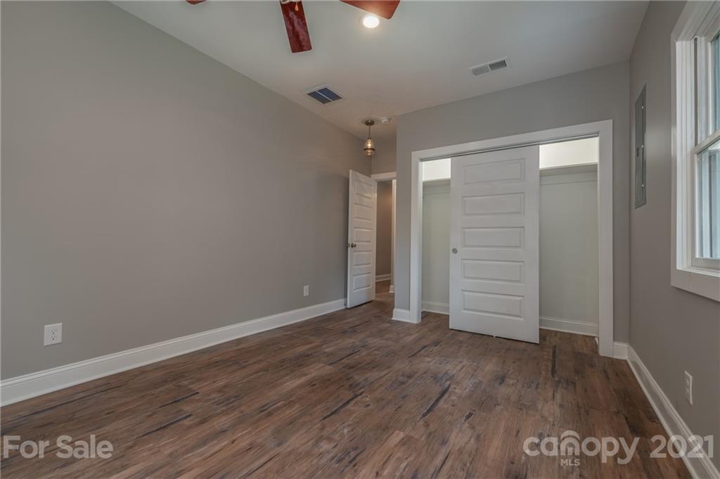 196 Caledonia Road Landrum, SC 29356 - Photo 17 of 26 an empty room with wooden floor and windows