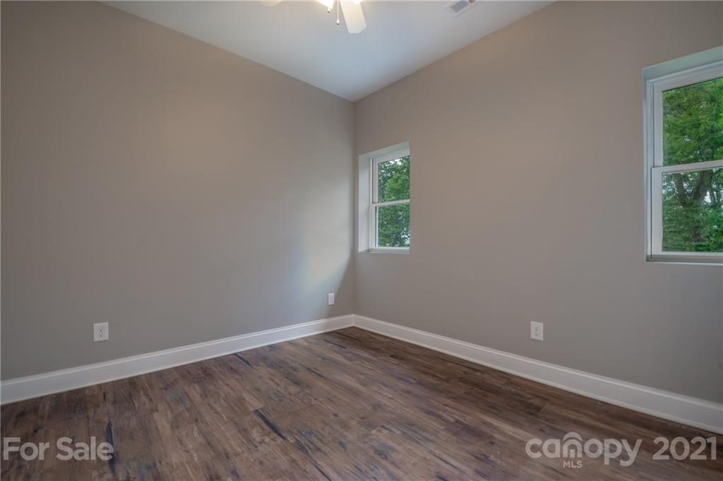 196 Caledonia Road Landrum, SC 29356 - Photo 19 of 26 an empty room with wooden floor and windows