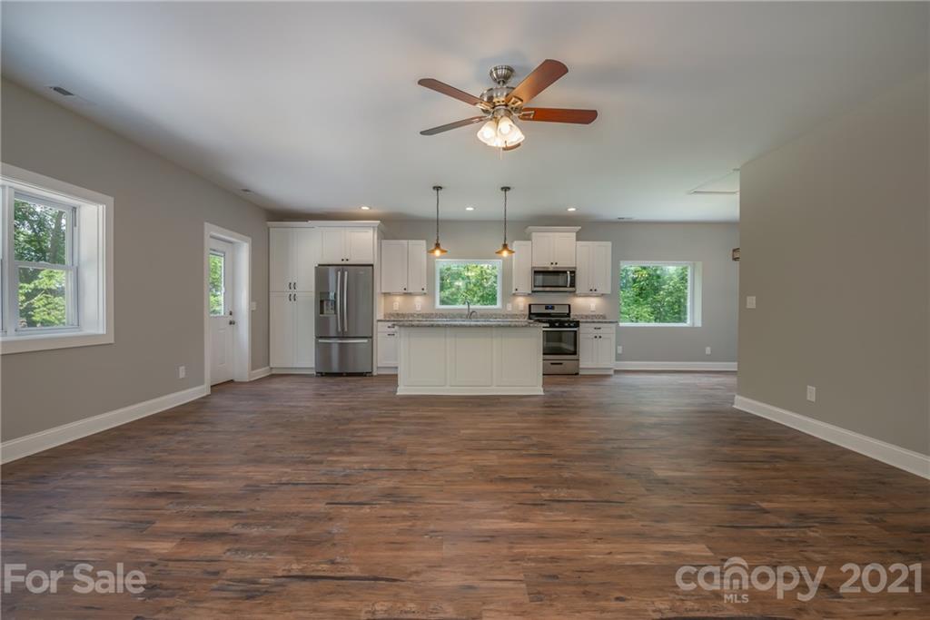 196 Caledonia Road Landrum, SC 29356 - Photo 3 of 26 a view of a livingroom with a ceiling fan and wooden floor