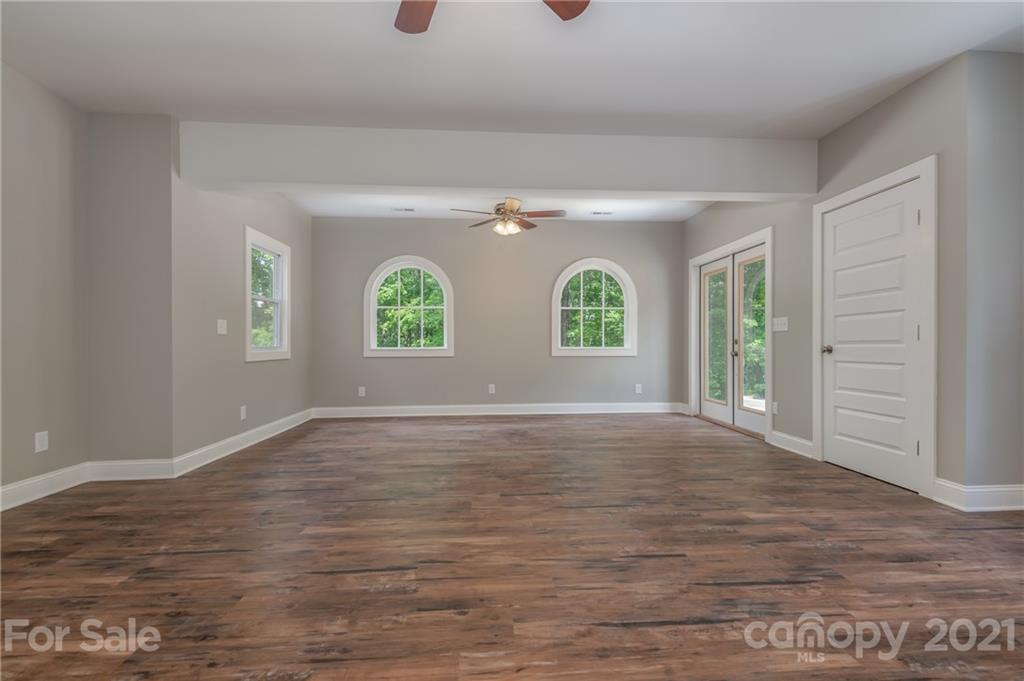 196 Caledonia Road Landrum, SC 29356 - Photo 4 of 26 a view of an empty room with wooden floor and window