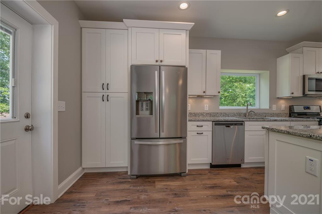 196 Caledonia Road Landrum, SC 29356 - Photo 6 of 26 a kitchen with granite countertop stainless steel appliances a refrigerator and a sink