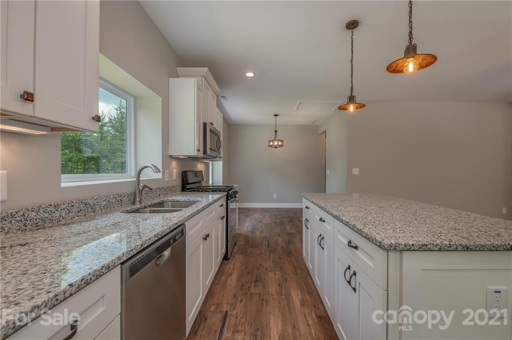 196 Caledonia Road Landrum, SC 29356 - Photo 7 of 26 a kitchen with a sink stove and cabinets