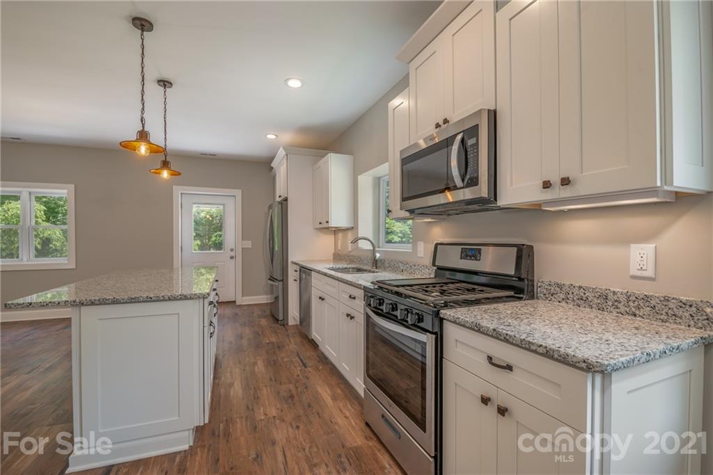 196 Caledonia Road Landrum, SC 29356 - Photo 8 of 26 a kitchen with stainless steel appliances granite countertop a stove a sink and a microwave