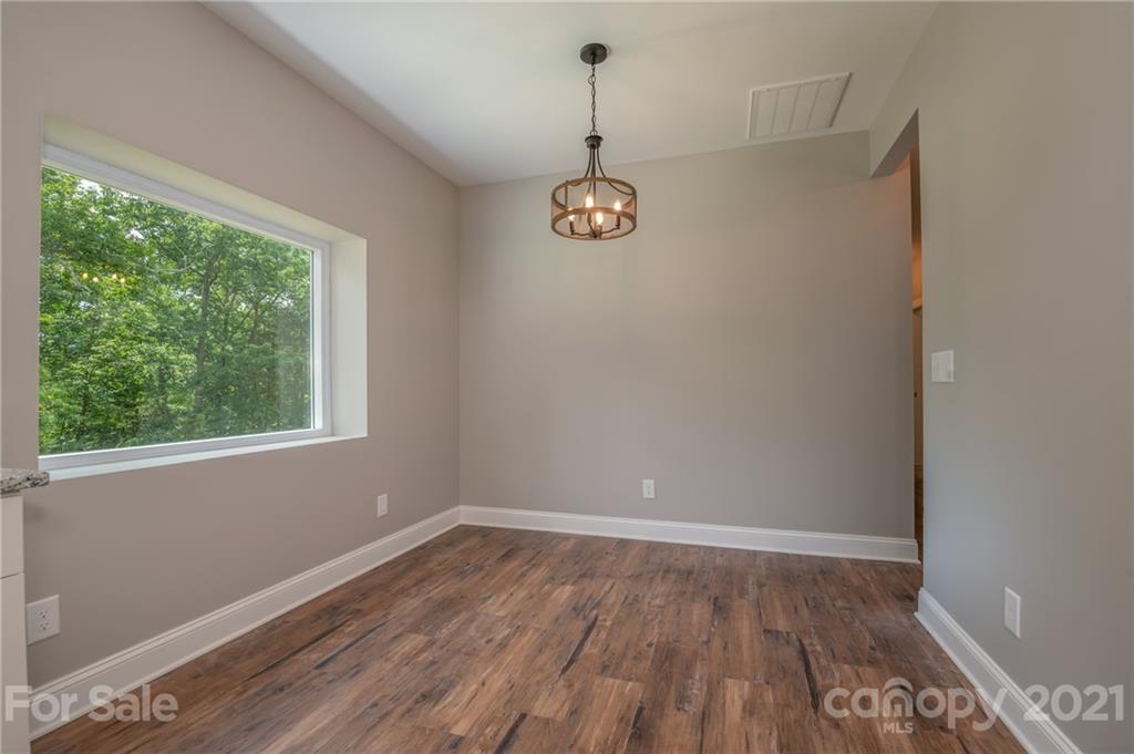 196 Caledonia Road Landrum, SC 29356 - Photo 9 of 26 wooden floor in an empty room with a window
